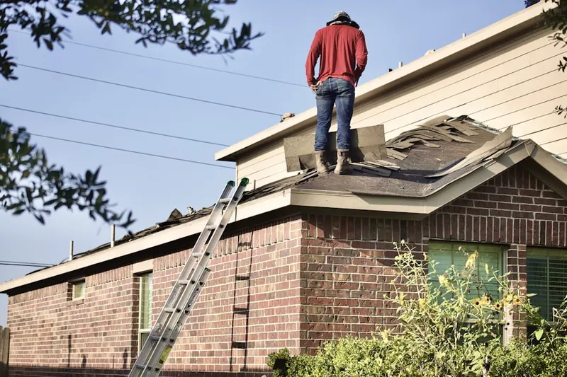 Professional roofer working on a residential roof in Hillside Manor